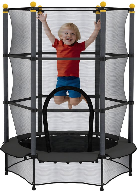 Lachend jongetje springt op zwarte trampoline met veiligheidsnet. Oranje shirt, blauwe korte broek.