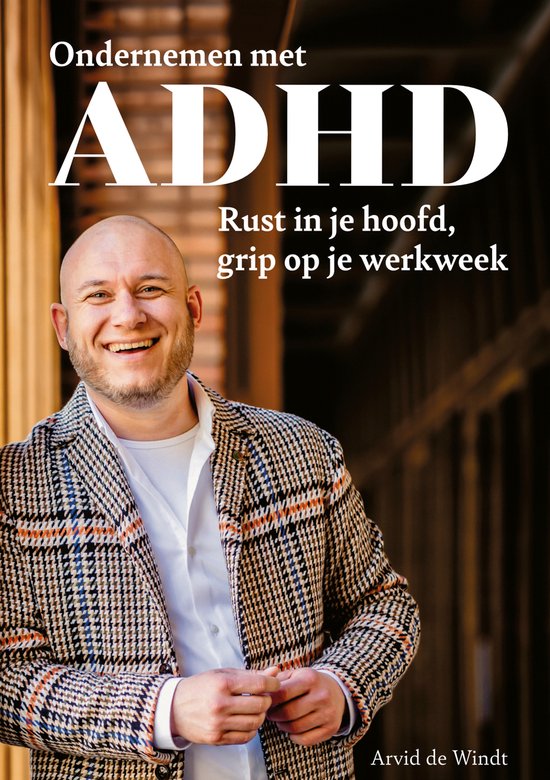 Man met baard in een geruit jasje met ruitpatroon en wit shirt. Boek "Ondernemen met ADHD" met de tekst "Rust in je hoofd, grip op je werkweek".