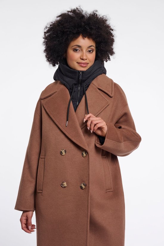 Model draagt een bruine jas met dubbele knopen en een zwarte hoodie.