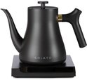 Zwarte CHiATO waterkoker met gouden accent op het handvat, op een zwarte standaard.