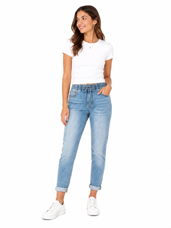 Model draagt een lichte spijkerbroek met hoge taille, trekkoord en witte T-shirt.