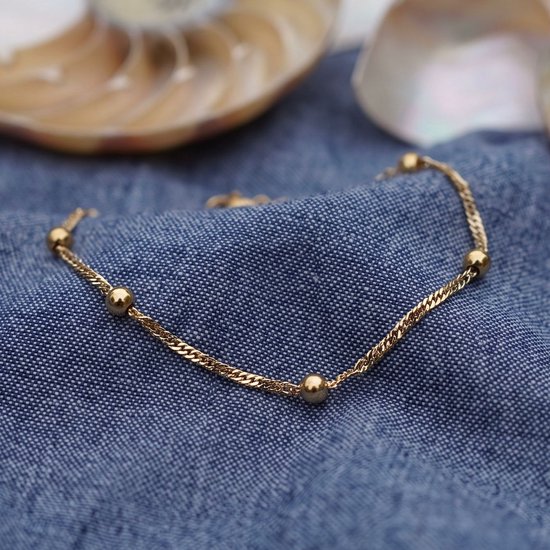 Gouden armband met een fijne ketting en afwisselend kleinere en grotere goudkleurige bolletjes.