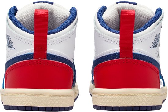 Achterkant van witte peutersneakers met rode en blauwe vlakken aan de hiel en blauwe veters.