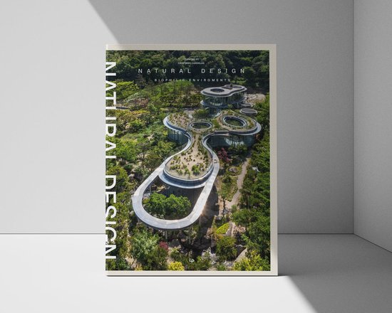 Boek met de titel 'Natural Design Biophilic Environments' met een vogelvluchtafbeelding van een modern gebouw met een groen dak, omgeven door bomen.
