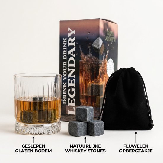 Een glas met whiskey, natuurlijke whiskey stones en een zwart opbergzakje naast een doos.