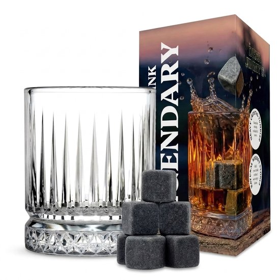 Un verre à whiskey vide aux côtés rainurés et au fond détaillé, à côté de pierres à whiskey empilables et d'une boîte.