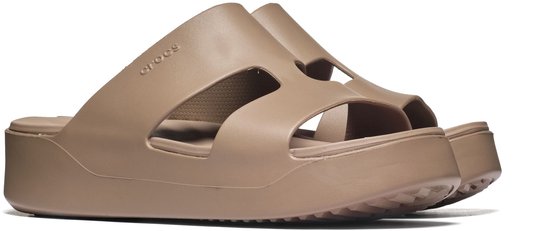 Twee bruine Crocs slippers met kruisende bandjes en plateauzolen, op de zijkant gefotografeerd.