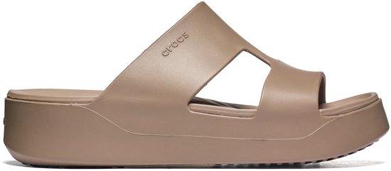 Zij-aanzicht van een bruine Crocs slipper met open zijkanten en plateauzool.