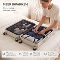 Vrouw pakt een beige koffer in op een bed, met interne opbergvakken.