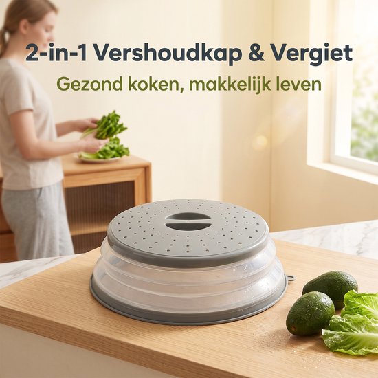 Grijze, opvouwbare magnetronafdekking op een houten snijplank met avocado's en sla, een vrouw met groenten op de achtergrond.