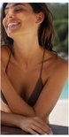 Vrouw met gesloten ogen en een brede glimlach, lichte huid, bruine bikini.