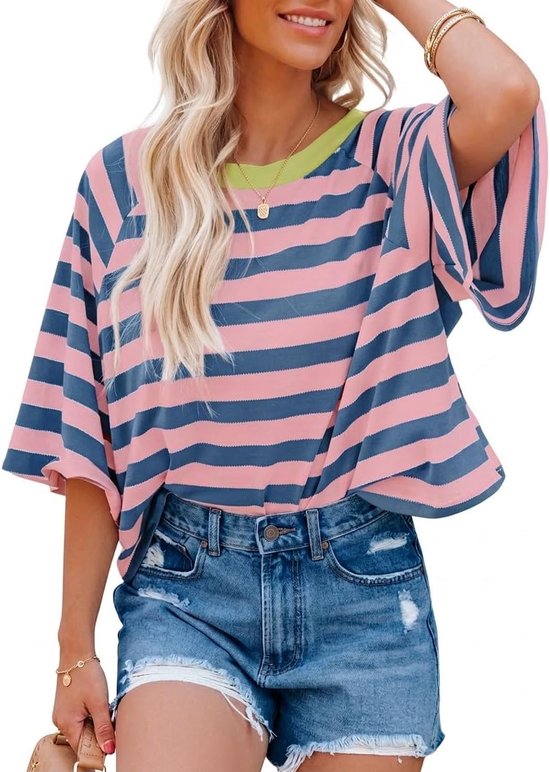 Model draagt een roze en blauw gestreept T-shirt met wijde, korte mouwen en een lichtgroene halslijn, gecombineerd met een spijkerbroek.