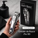 Hand met zilverkleurige Royce Pro 90 tondeuse met digitaal display, naast de productverpakking.