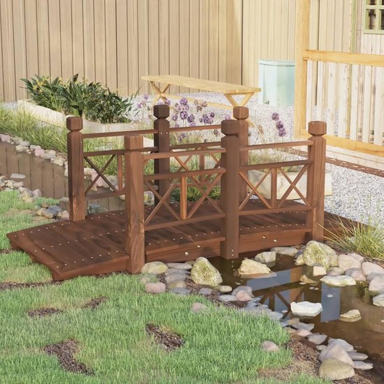 Een houten tuinbrug met leuningen staat over een kleine vijver in een tuin met gras en stenen.