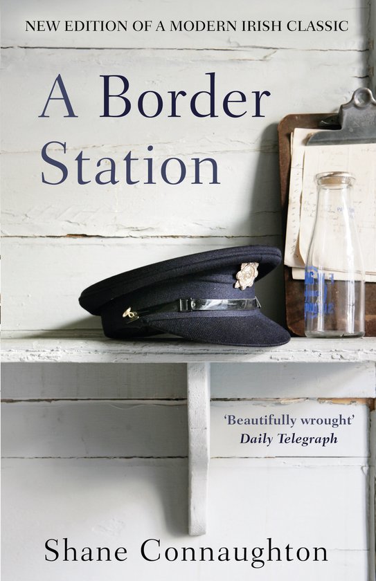 Boekomslag A Border Station van Shane Connaughton met een politiepet op een witte houten plank en een glazen fles.