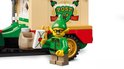 LEGO elf met bril en kerstmuts, naast de truck, met een brief met 'POST NORTH POLE'.