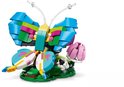 Papillon Lego coloré avec des accents verts, bleus, roses et jaunes sur une base verte avec une fleur rose.