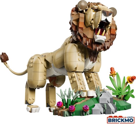 Gele lego leeuw met bruine manen, witte tanden en een groene, stenige omgeving met roze bloemen.