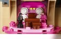 LEGO Harry Potter en Ginny Wemel staan naast een bruine stoel met roze details.