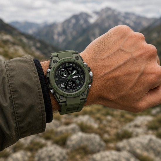 Groen sport horloge gedragen door een man met een groene jas in de bergen. "SPORT WATCH" opschrift.