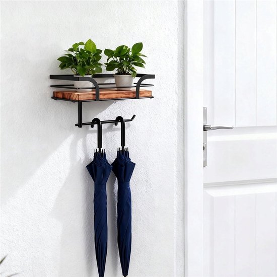Zwarte wandrek met houten plank en kapstok. Met twee plantjes en twee blauwe paraplu's.