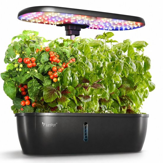 Zwarte kweekbak met een volle LED-lamp en een overvloed aan verse kruiden en tomaatjes.