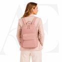 Vrouw in een roze blazer met een roze rugzak.