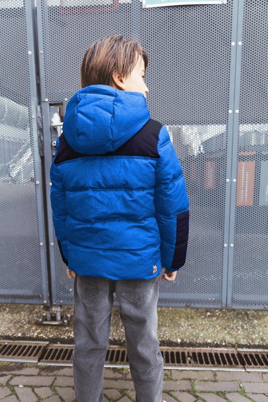 Jongen van achteren in een blauw met zwart gewatteerd jack met contourpatroon en capuchon.