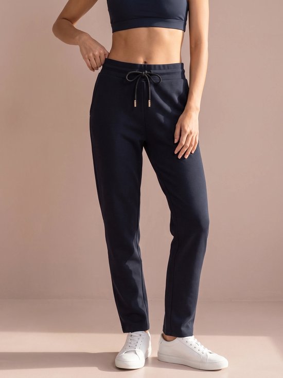 Donkerblauwe sportbroek op model, met trekkoord en steekzakken.