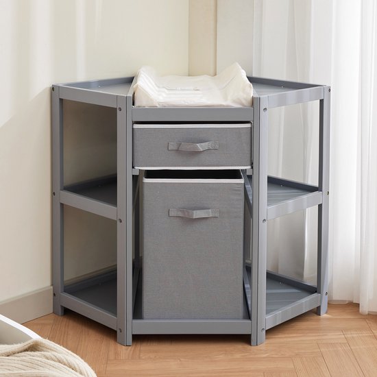 Grijze commode met stoffen lades en vakken, geplaatst in een hoek.
