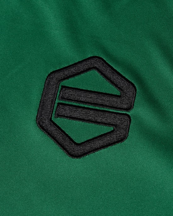 Detail van een groen sportshirt met een geborduurd zwart logo.