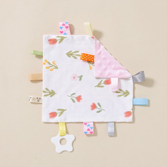 Wit labeldoekje met bloemenpatroon en roze, gepolsterde achterkant. Met gekleurde lintjes en een witte bijtring.
