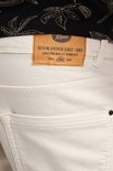 Close-up van het leren label op de achterkant van een beige short.