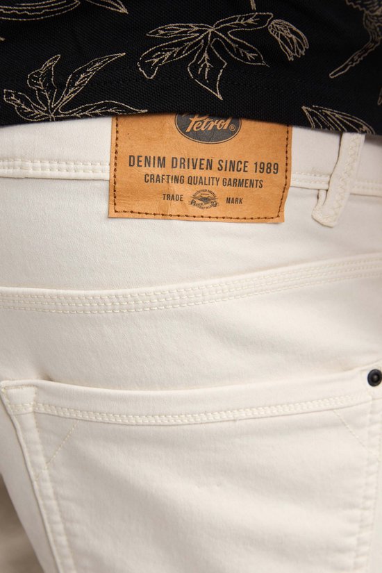 Close-up van het leren label op de achterkant van een beige short.