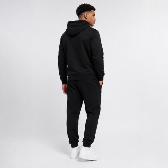 Achterkant man in zwarte hoodie en joggingbroek.