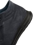 Detail van de hiel van een donkerblauwe suède sneaker met gestikte details en zwarte zool.