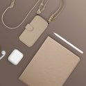 Beige telefoonhoes met koord, naast een tablet, oortjes en een stylus pen op een bruine ondergrond.