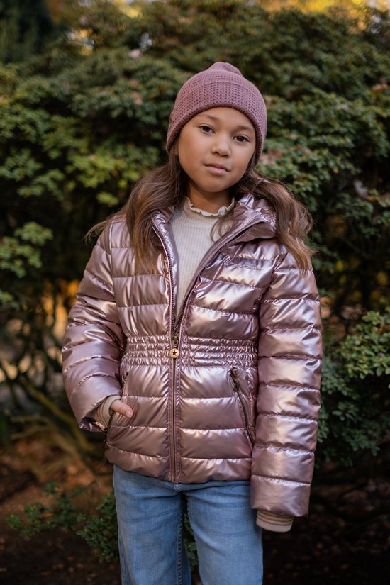 Meisje met roze muts draagt roze glanzende jas, crème coltrui en blauwe jeans