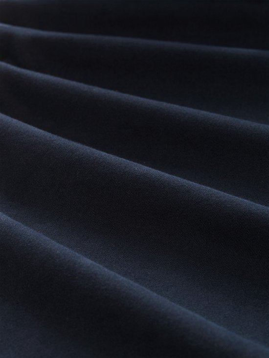 Close-up van de marineblauwe katoenen stof van de chino met subtiele textuur.