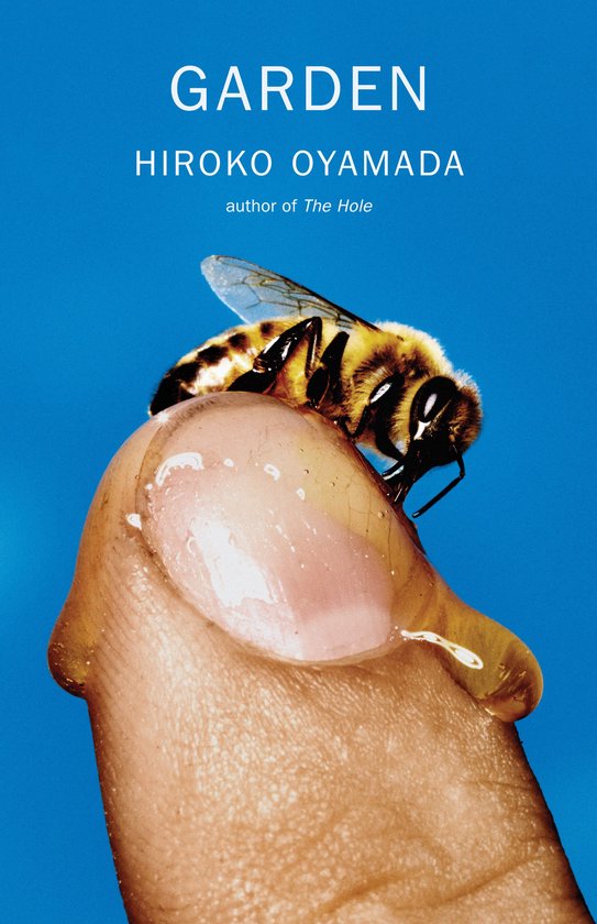 Boek "GARDEN" van HIROKO OYAMADA met op een duim zittende bij op blauwe achtergrond.