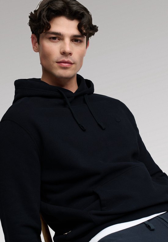 Close-up van model met donkerblauwe hoodie, de capuchon omhoog.