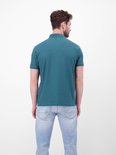 Achterkant van een blauwe polo met donkerblauwe kraag en knopen, model