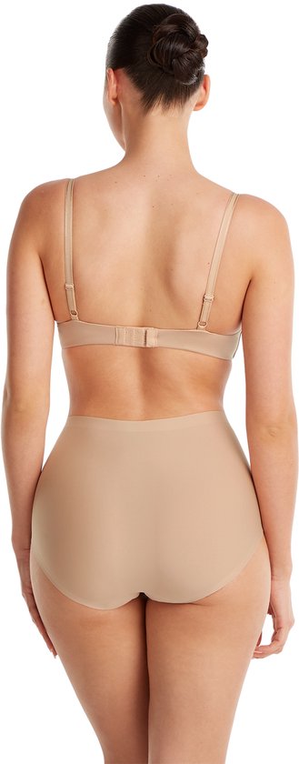 Vrouw, van achteren gezien, draagt een naadloze, huidkleurige high-waist slip met een bijpassende bh. Zwart achtergrond.