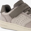 Close-up van de grijze Skechers sneaker met beige zool en klittenbandsluiting.