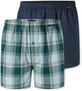Twee boxershorts, één met groene en lichtblauwe ruit, de ander effen donkerblauw. Beide met Schiesser logo.