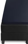 Donkerblauw jersey topper hoeslaken op een zwart matras.