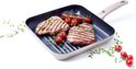 Grijze grillpan met bruine steel, twee gegrilde steaks, cherrytomaatjes en tijm.