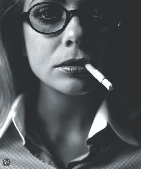 Close-up van een vrouw met bril en sigaret in haar mond. Zwart-wit.