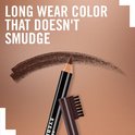 Een donkerbruin wenkbrauwpenseel van Rimmel London trekt een veeg op een bruine achtergrond. Tekst: Long wear color that doesn't smudge.