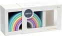 Verpakking van dëna speelgoed met een pastelkleurige regenboog, met 'My first rainbow!' op de voorkant.
